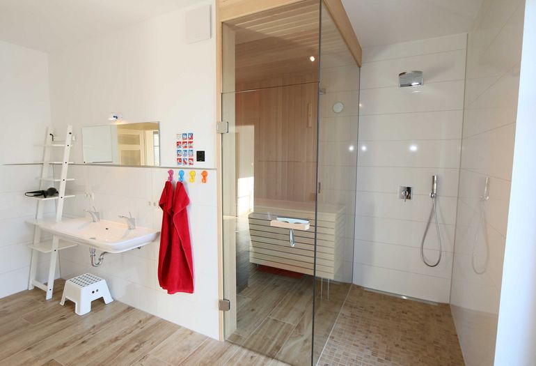 Badezimmer mit ebenerdiger Dusche und Sauna