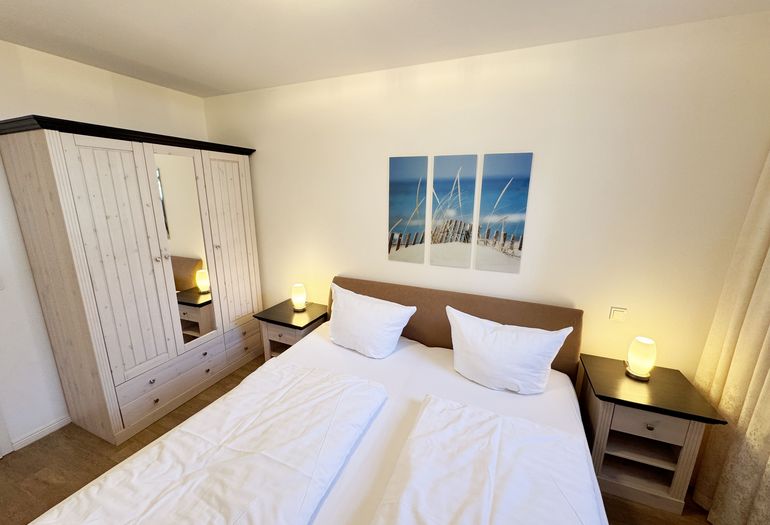 Schlafzimmer mit Doppelbett und Kleiderschrank