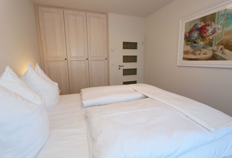 Schlafzimmer mit Doppelbett und Kleiderschrank