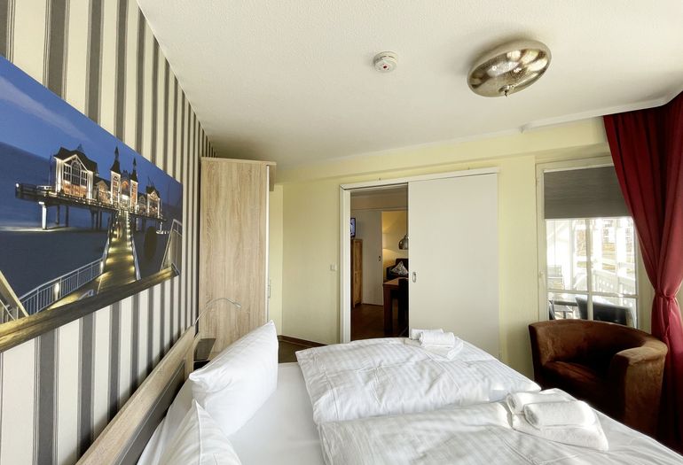 Schlafzimmer mit Doppelbett, Sessel und Kleiderschrank