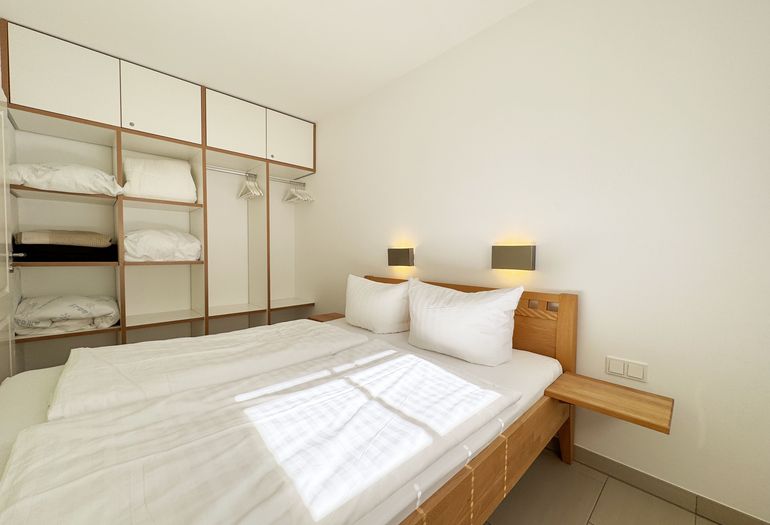 Schlafzimmer mit Doppelbett und offenen Kleiderschrank