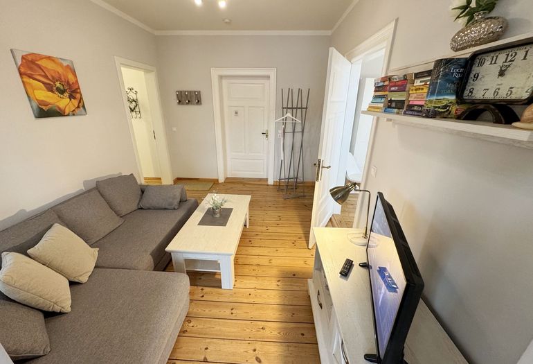 Wohnzimmer mit gemütlicher Couch und Flachbild-TV