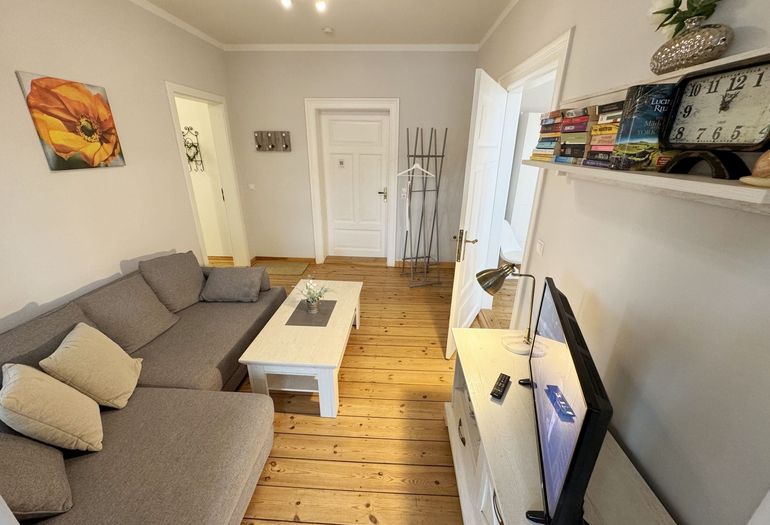 Wohnzimmer mit gemütlicher Couch und Flachbild-TV Wohnzimmer mit gemütlicher Couch und Flachbild-TV