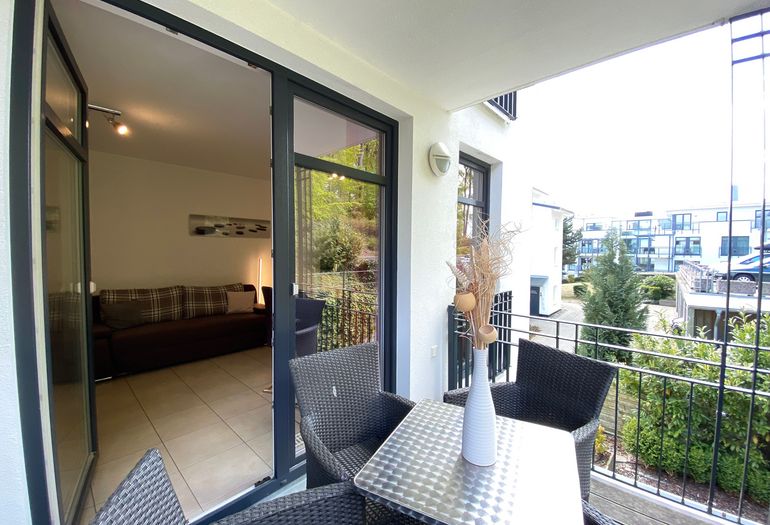 bestuhlter Balkon mit Blick ins Wohnzimmer