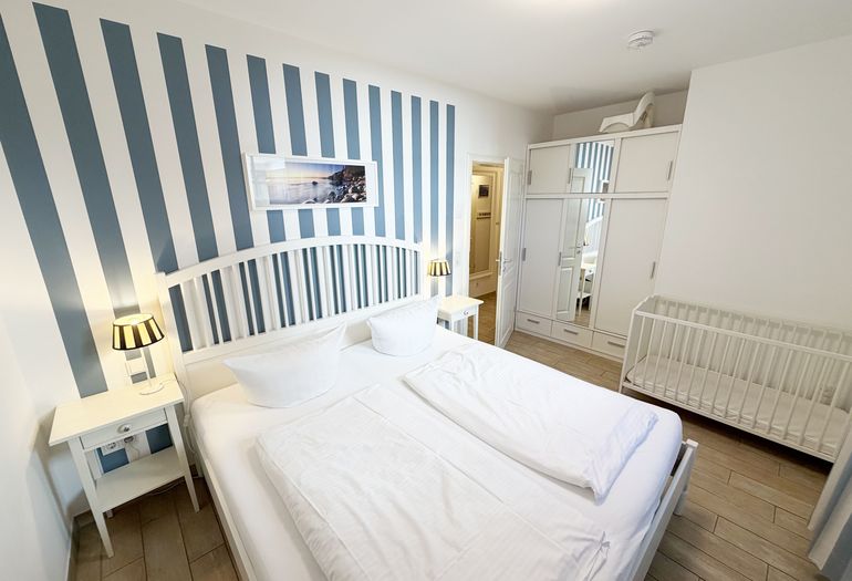 1. Schlafzimmer mit Doppelbett, Kleiderschrank und Nachttischablagen