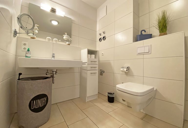 Badezimmer mit Waschbecken und großem Spiegel