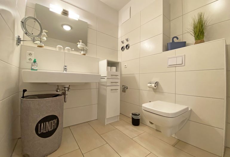 Badezimmer mit Waschbecken und großem Spiegel