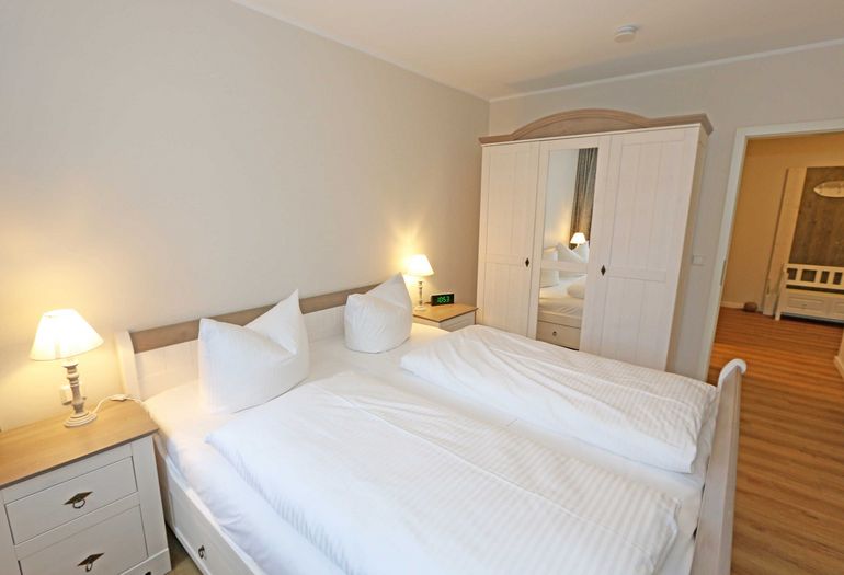 Schlafzimmer mit Doppelbett und Kleiderschrank