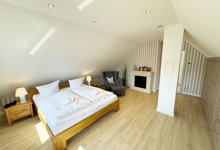 1. Schlafzimmer mit Doppelbett und Elektrokamin