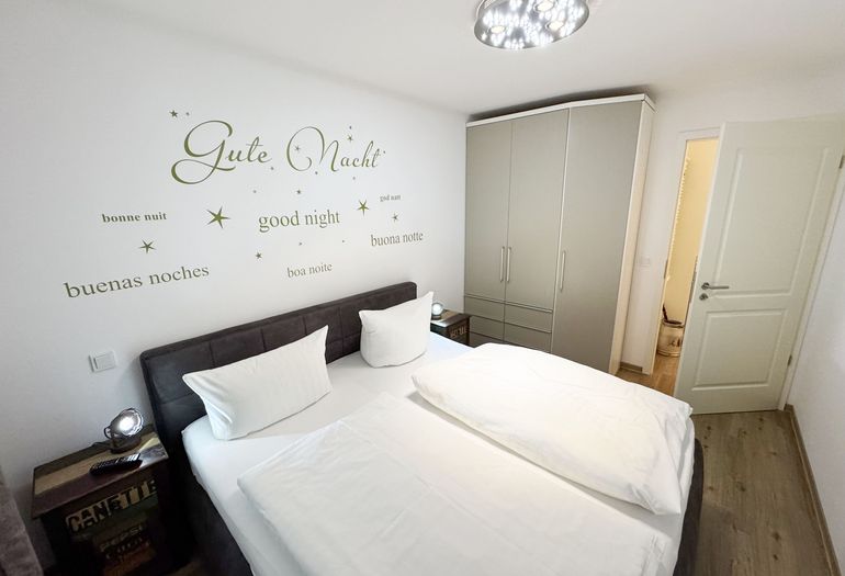 Schlafzimmer mit Doppelbett und Kleiderschrank