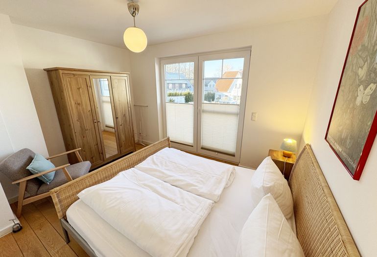 Schlafzimmer mit Doppelbett und Kleiderschrank