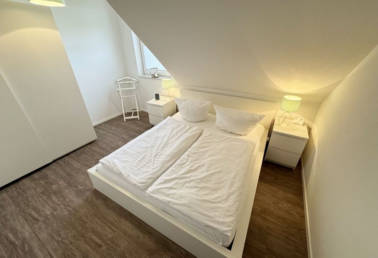 Blick auf das Doppelbett und den angrenzenden Kleiderschrank