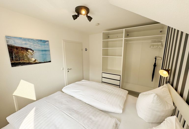 Schlafzimmer mit offenem Kleiderschrank