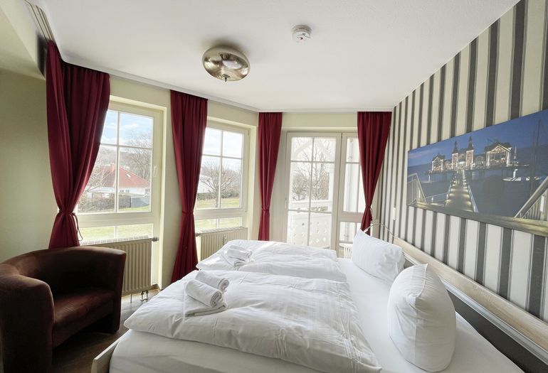 Schlafzimmer mit Doppelbett, Sessel und Kleiderschrank