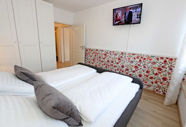 Schlafzimmer mit Doppelbett und TV