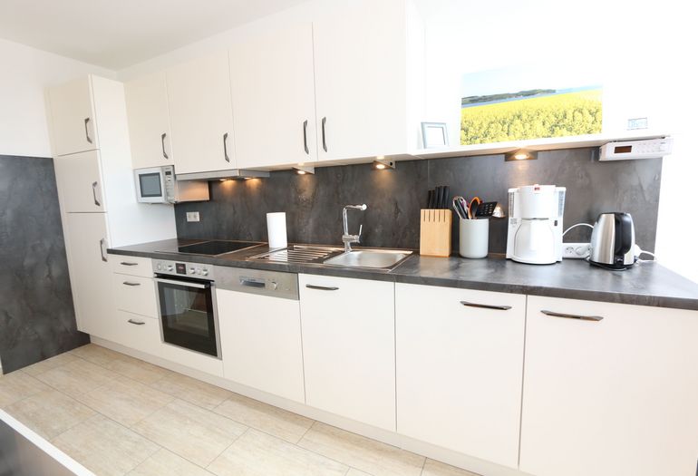 Küchenzeile mit Mikrowelle und diversen Küchenutensilien