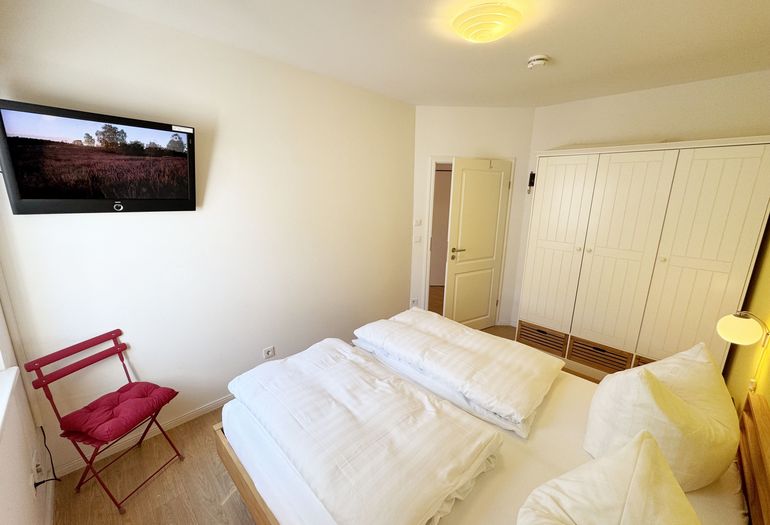 Schlafzimmer mit Doppelbett und Kleiderschrank