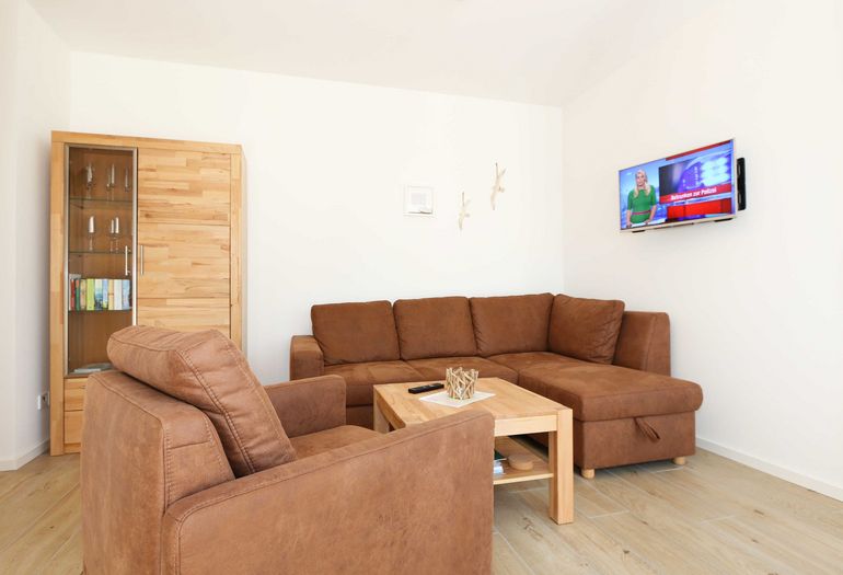 Wohnzimmer mit TV, Couch und Sessel