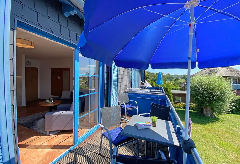 bestuhlter Balkon mit Blick ins Wohnzimmer