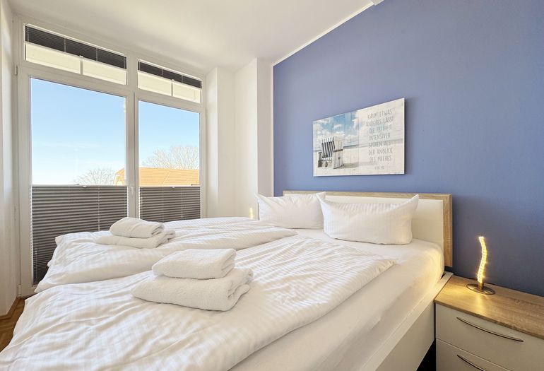 Schlafzimmer mit Doppelbett und Nachttischablagen