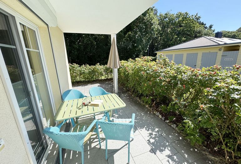 bestuhlte und überdachte Terrasse mit Sonnenschirm