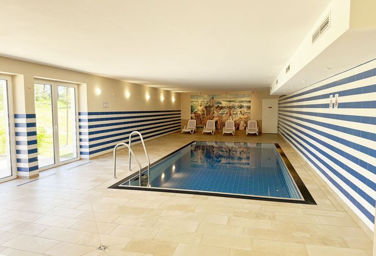 Wellnessbereich mit Pool und Liegen