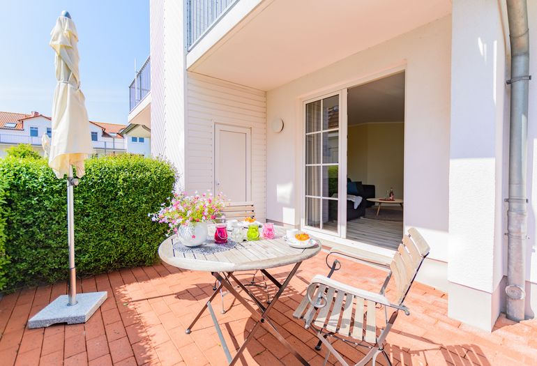 bestuhlte Terrasse durch eine Hecke geschützt