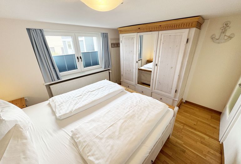 Schlafzimmer mit Doppelbett und Kleiderschrank