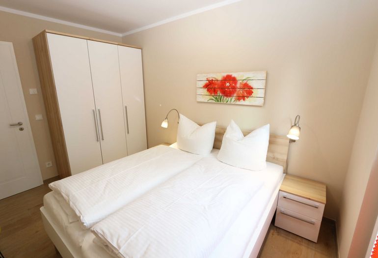 Schlafzimmer mit Doppelbett und Kleiderschrank