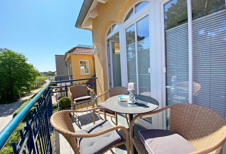 bestuhlter Balkon mit Blick zu den Kiefern