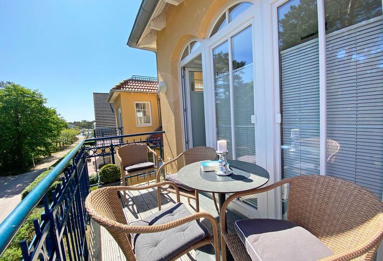 bestuhlter Balkon mit Blick zu den Kiefern