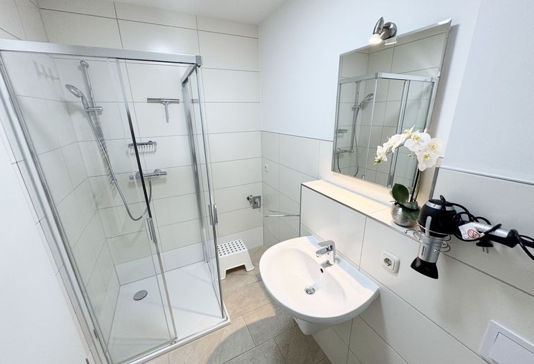 Badezimmer mit ebenerdiger Dusche und Waschbecken Badezimmer mit ebenerdiger Dusche und Waschbecken