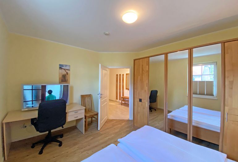 zweites Schlafzimmer mit TV und Schreibtisch