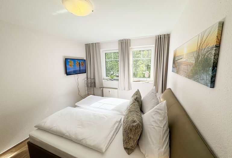 Schlafzimmer mit Doppelbett und TV