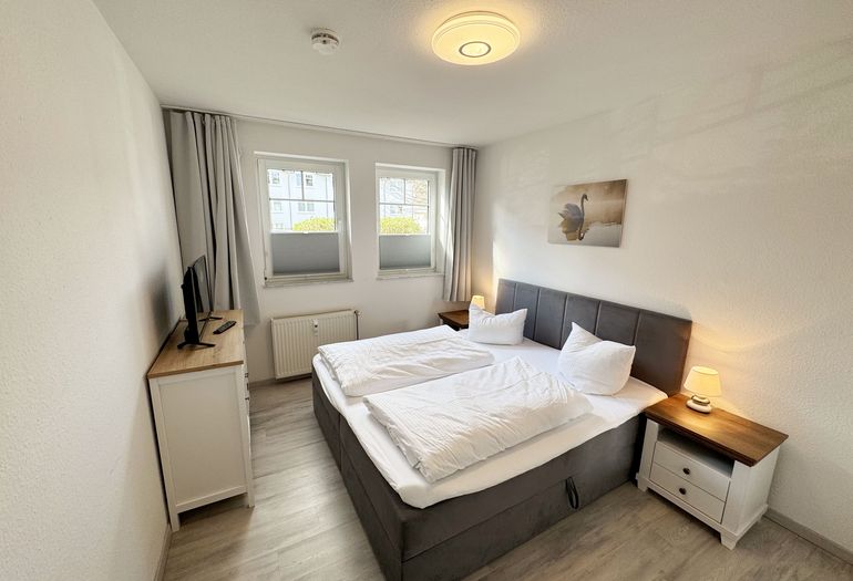 Schlafzimmer mit Doppelbett und TV