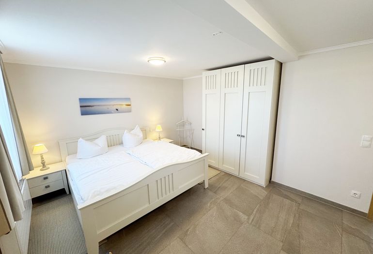 Schlafzimmer mit Doppelbett und Einzelbett und Kleiderschrank