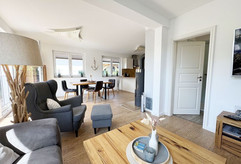 Wohnbereich mit gemütlicher Eckcouch und Ohrensessel mit Hocker