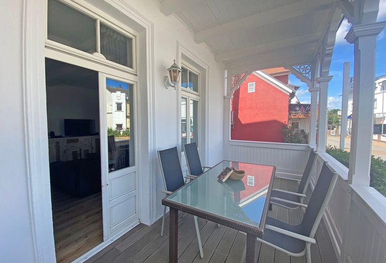 bestuhlter Balkon mit Blick ins Wohnzimmer