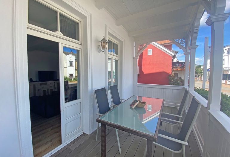 bestuhlter Balkon mit Blick ins Wohnzimmer