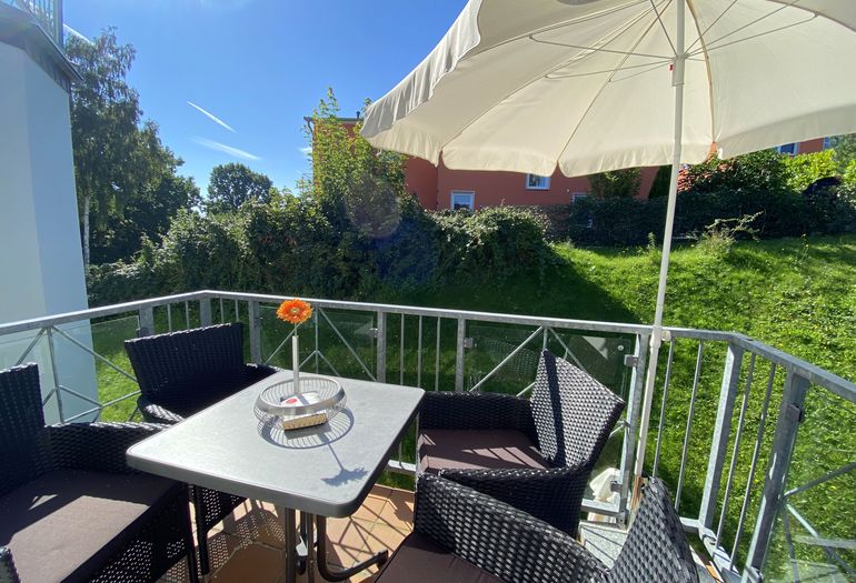 bestuhlter Balkon mit Blick ins Grüne