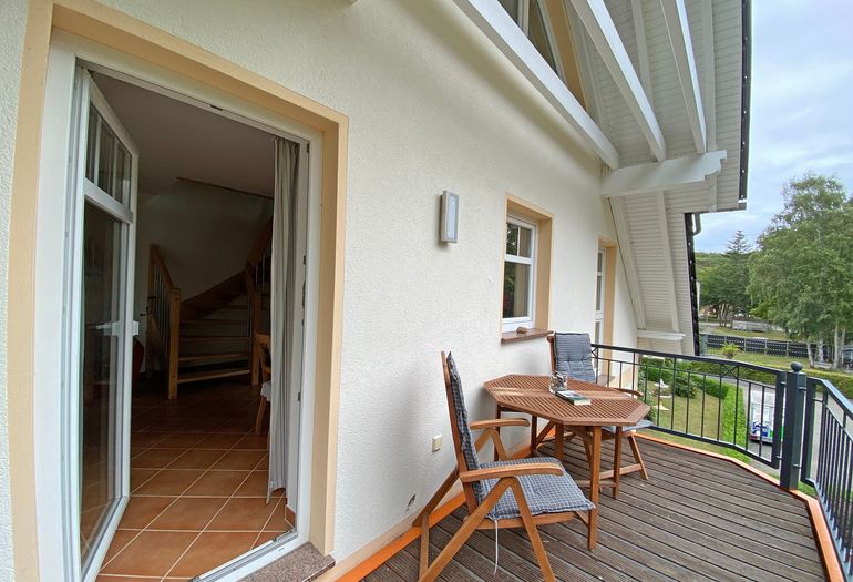 bestuhlter Balkon mit Blick in den Wohnbereich