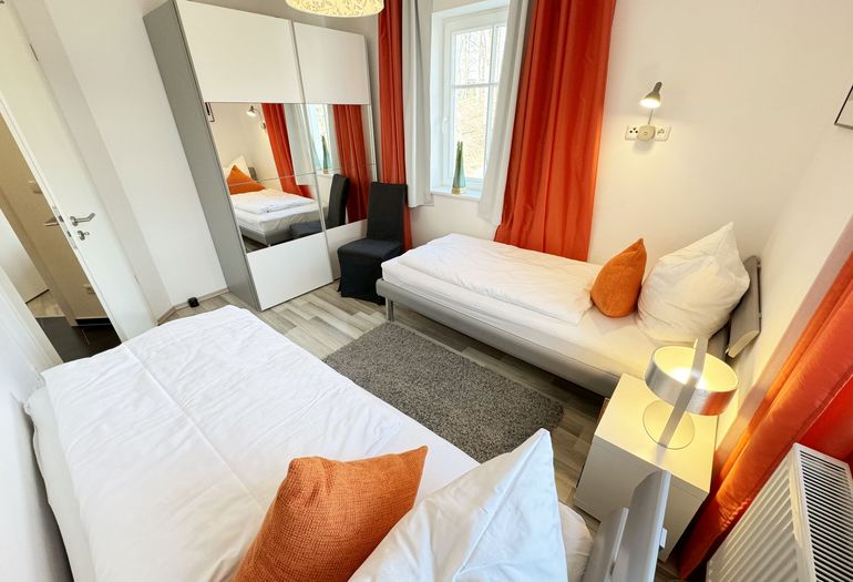 Villa Wilhelmine WE 04 Schlafzimmer mit 2 Einzelbetten und Kleiderschrank Villa Wilhelmine WE 04 Schlafzimmer mit 2 Einzelbetten und Kleiderschrank