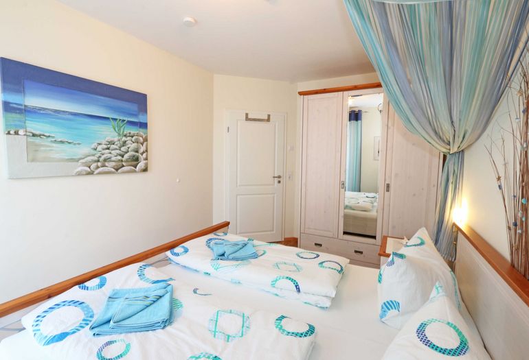 Schlafzimmer mit Doppelbett und Kleiderschrank