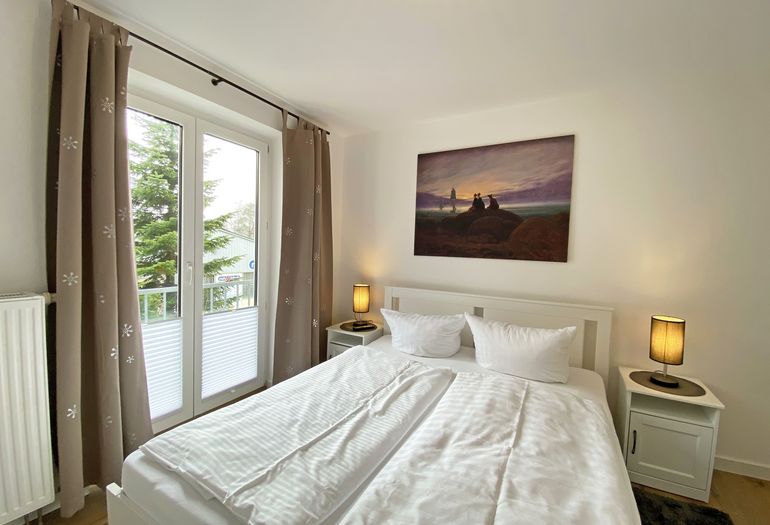 Schlafzimmer mit Doppelbett und TV