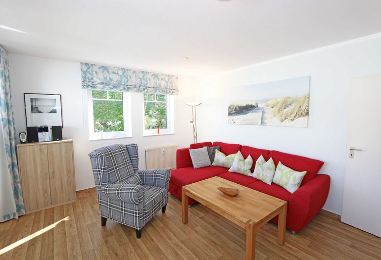 Wohnzimmer mit Couch und Sessel