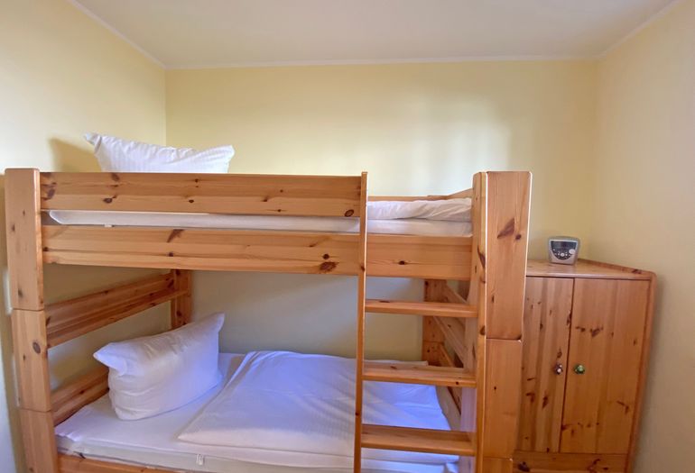 drittes Schlafzimmer mit Doppelstockbett und kleinem Schrank