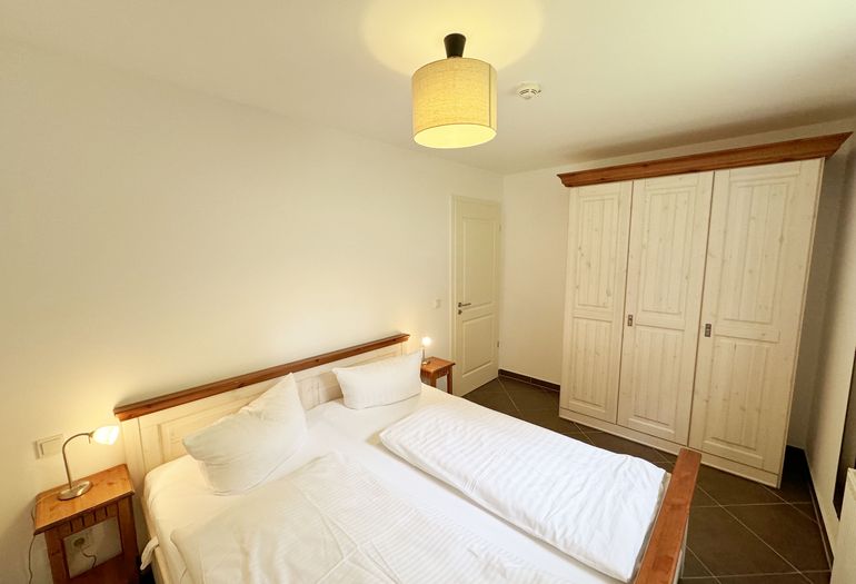 Schlafzimmer mit Doppelbett und Kleiderschrank