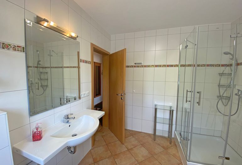 Badezimmer mit Dusche und Waschbecken
