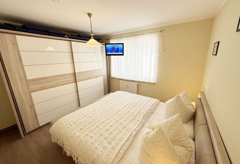 Schlafzimmer mit Doppelbett und Kleiderschrank