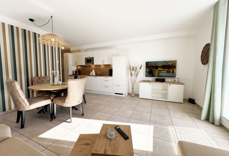 gemütlicher Wohnbereich mit angrenzender Küchenzeile und Esstisch